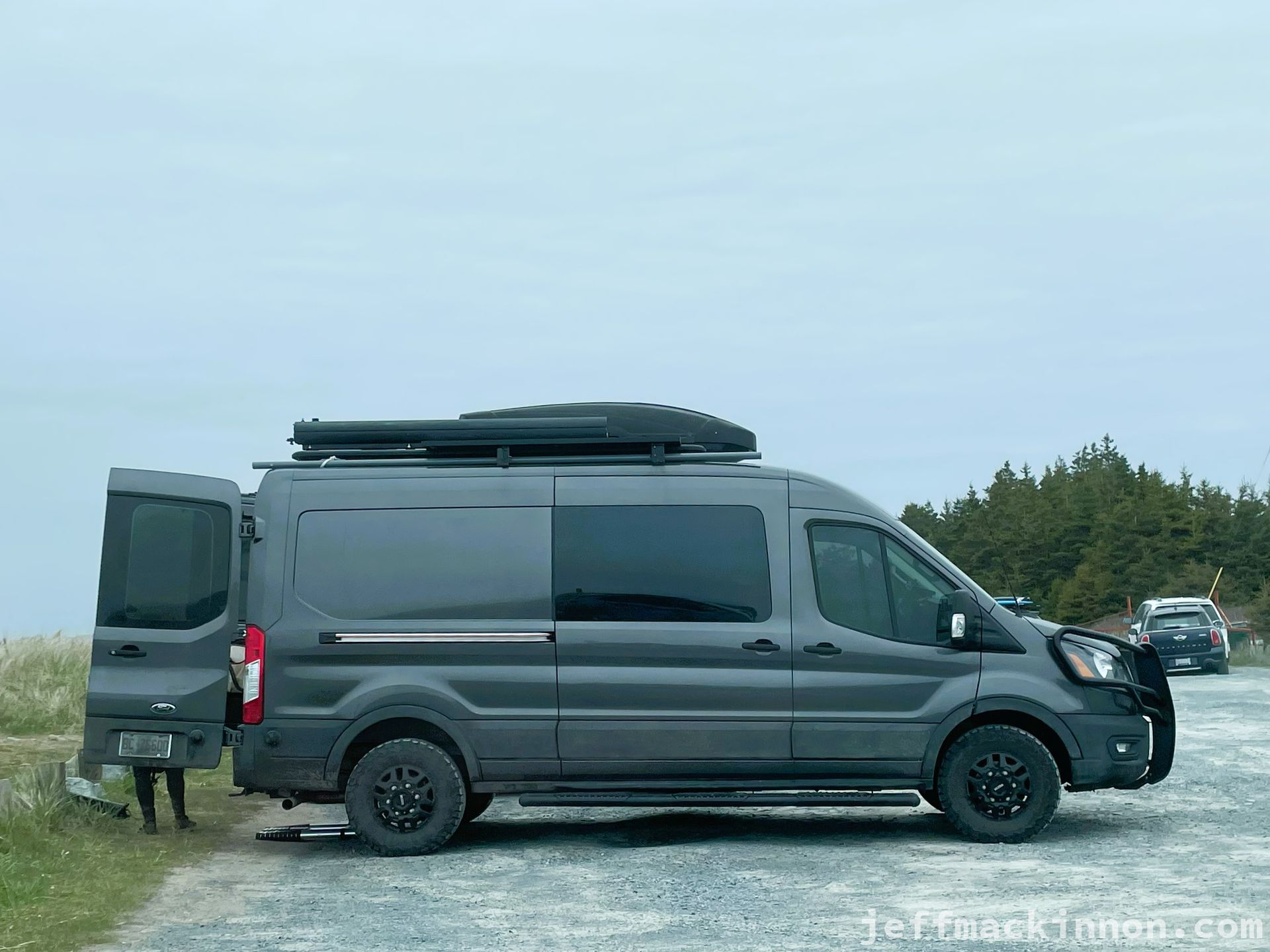 A very cool, dark grey, converted ford transit van.